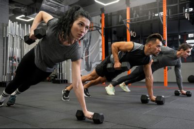 people working out indoors together with dumbbells